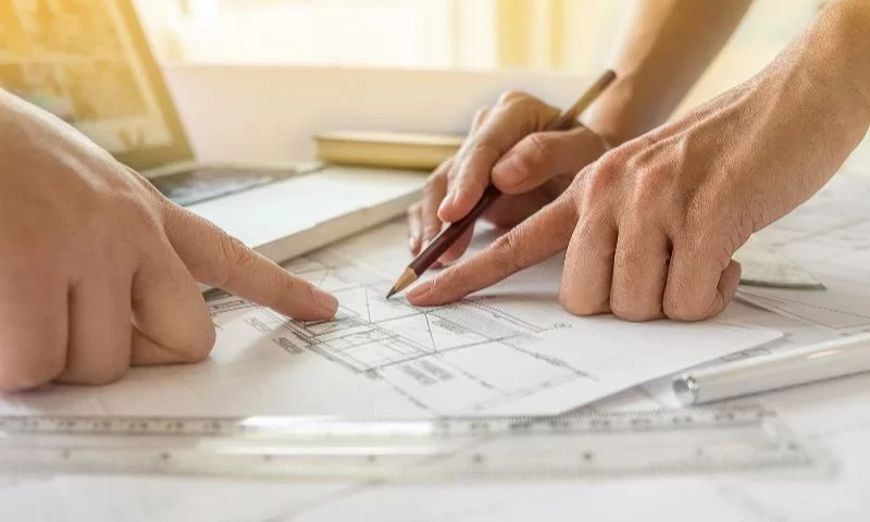 Hands of Engineers working on blueprint