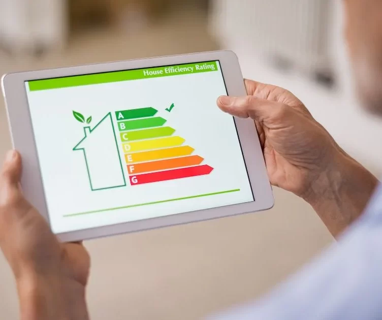 Man holding digital tablet and looking at house efficiency rating.