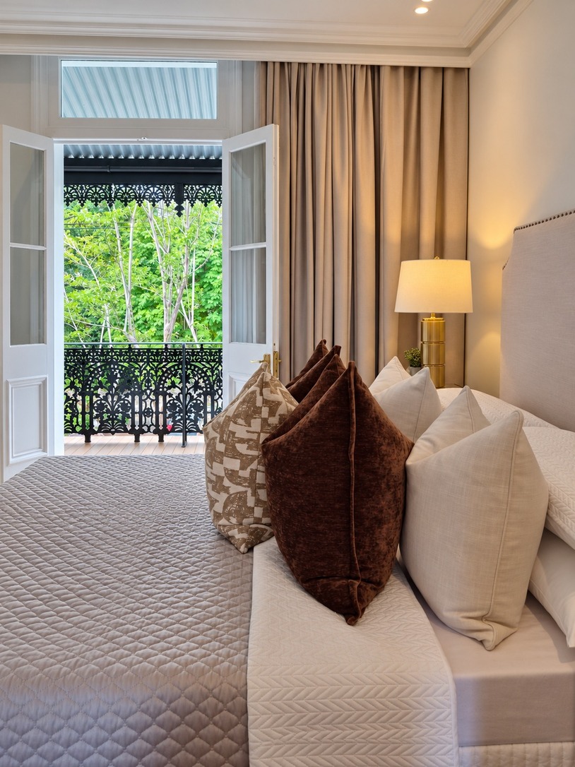 Bedroom opening to a cast-iron lace balcony at the front of a Paddington heritage terrace