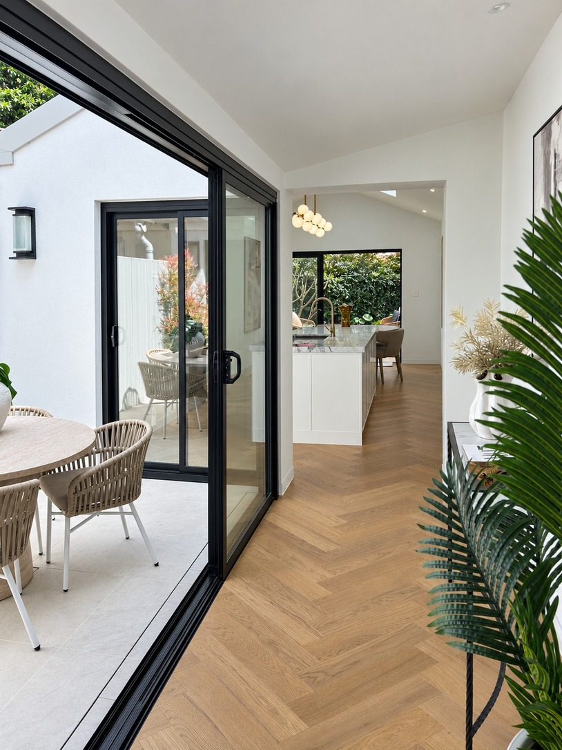 Herringbone hallway beside the courtyard, connecting living and kitchen spaces in a terrace house design