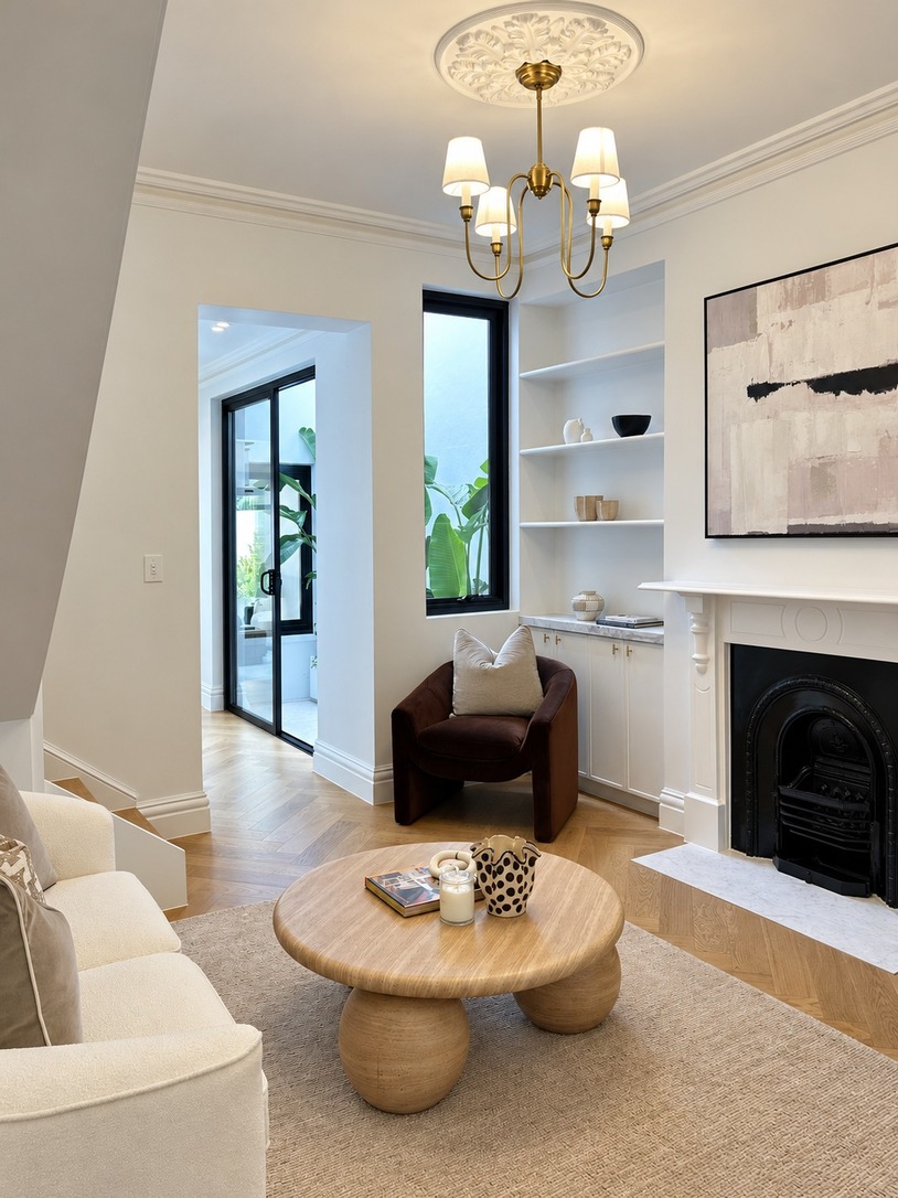 Living room with fireplace, built-in shelving and chandelier in a renovated Sydney terrace house
